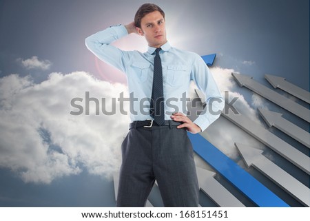 Thinking businessman with hand on head against green arrows in a desert landscape