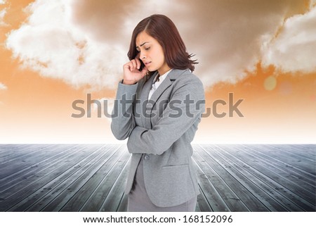Worried businesswoman against cloudy sky background