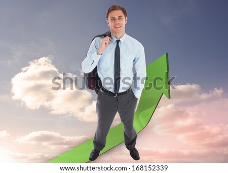 Smiling businessman holding his jacket against green curved arrow pointing up against sky