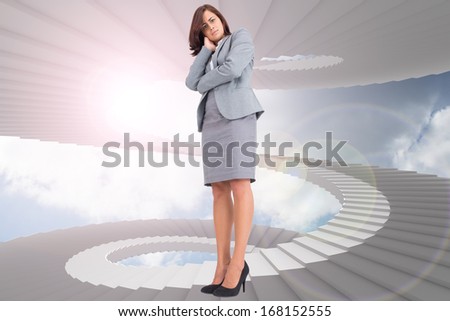 Focused businesswoman against winding staircase in the sky