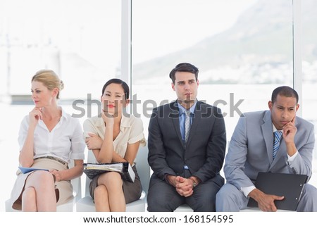 Four business people waiting for job interview in a bright office