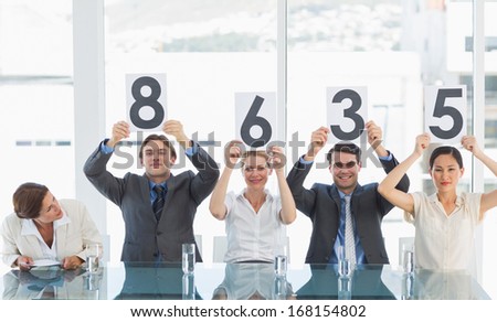 Portrait of a group of panel judges holding score signs
