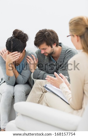 Displeased young couple in meeting with a financial adviser at home