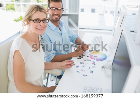 Side view portrait of photo editors working on computers in a bright office