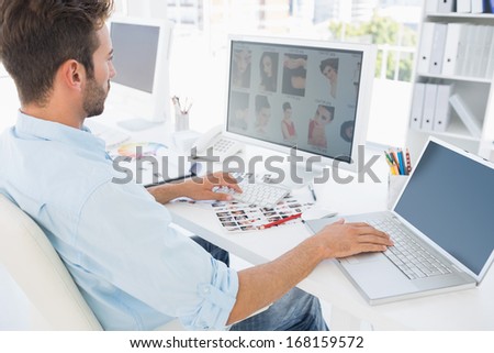 Side view of a male photo editor working on computer in a bright office