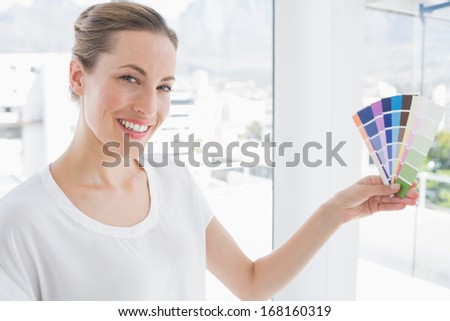 Portrait of a photo editor holding colors in a bright office