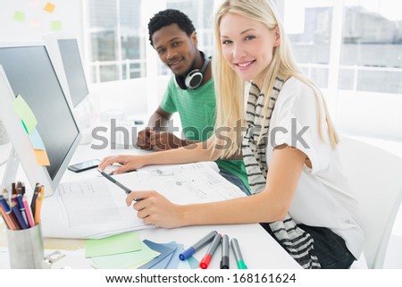 Side view portrait of a casual couple using computer in a bright office