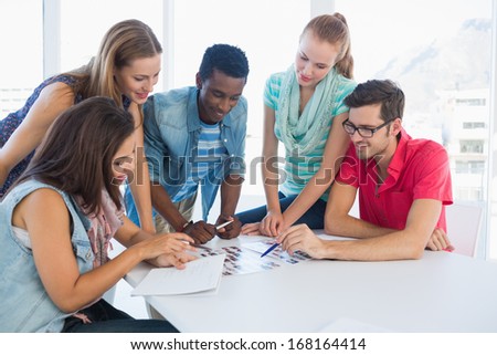 Group of casual artists working on designs in the creative office