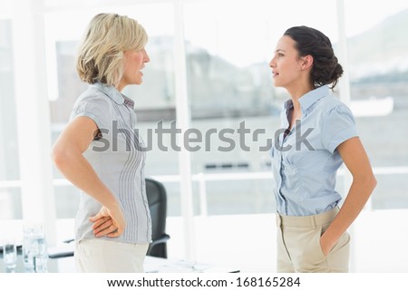 Side view of two businesswomen fighting in a bright office