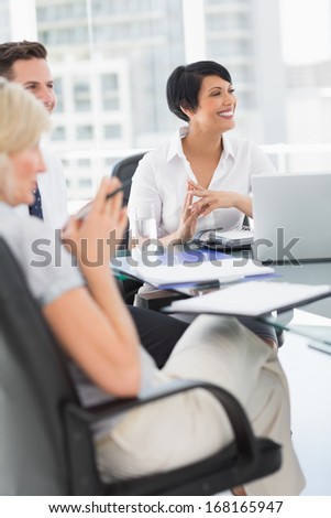 Young well dressed business people in discussion at a bright office