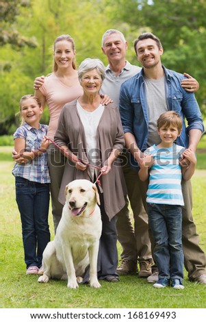 Portrait of an extended family with their pet dog standing at the park