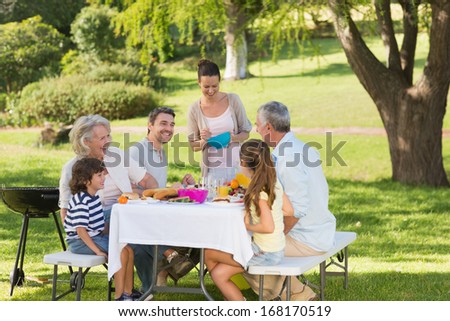 View Of Extended Family Dining At Outdoor Table