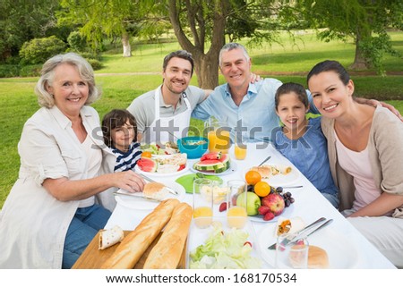 Portrait Of Extended Family Dining At Outdoor Table