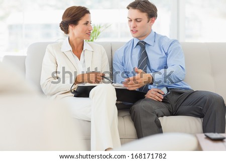 Business people planning in diary together on the sofa in the office