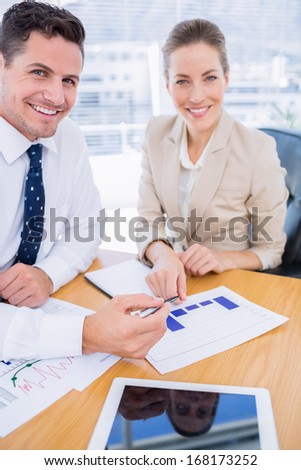 Smartly dressed young man and woman in a business meeting at office desk