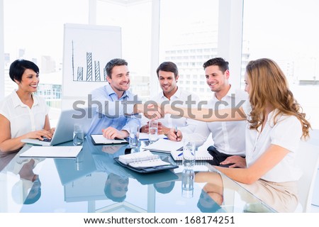 Smartly dressed executives shaking hands during a business meeting in the office