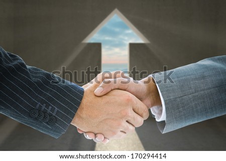 Composite image of business handshake against arrow door in dark room