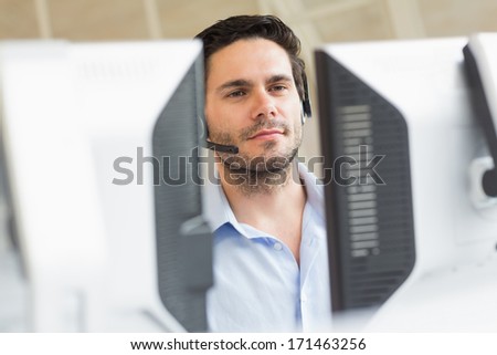 Male customer service representative using computer in call center