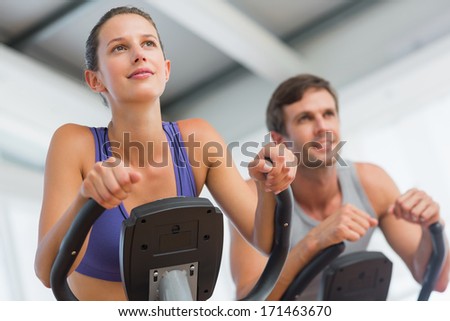 Smiling young man and woman working out at class in gym