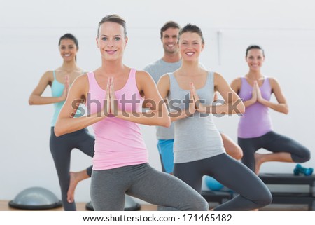 Portrait of sporty class with joined hands standing in fitness studio
