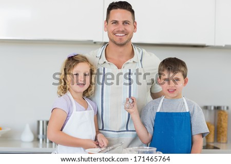 Portrait of smiling family in aprons baking cookies