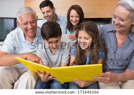 Happy extended family looking at their album photo in the living room