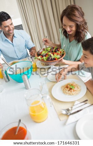 High angle view of happy family of three sitting at dining table in the home