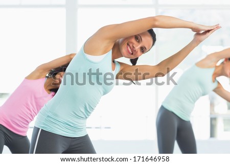 Portrait of smiling young women doing pilate exercises in the fitness studio