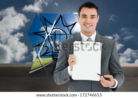 Businessman pointing with pen on clipboard against balcony and cloudy sky
