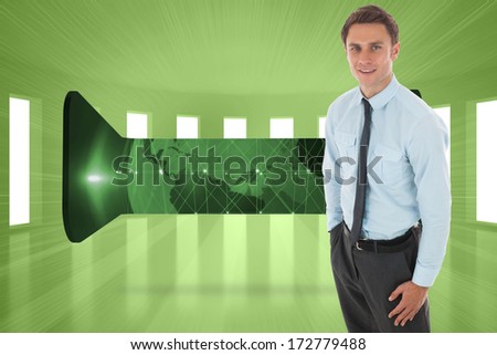 Happy businessman standing with hand in pocket against bright green room with windows