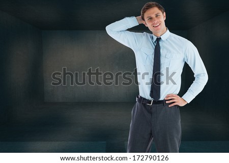Thinking businessman with hand on head against dark room