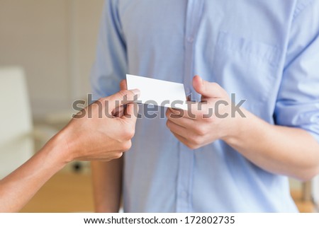 Cropped image of business people exchanging visiting cards in office
