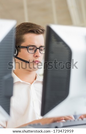 Male customer service agent using computer in call center