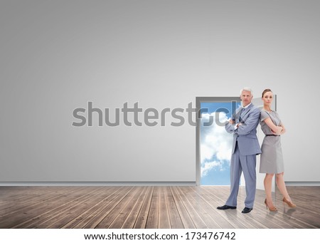 Serious businessman standing back to back with a woman against road leading out to the horizon