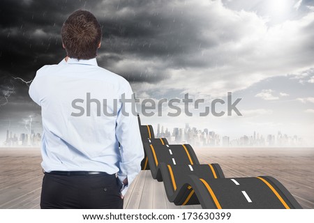 Businessman against red and blue curved arrows pointing against sky