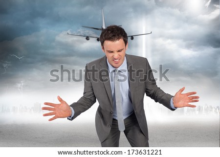 Businessman posing with hands out against city on the horizon with light beam