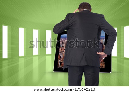 Thinking businessman scratching head against bright green room with windows