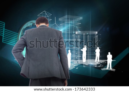 Businessman standing with hand on hip against shiny globe on black background