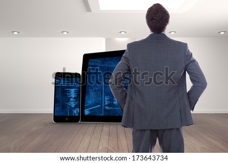 Businessman standing with hands on hips against digitally generated room with stairs