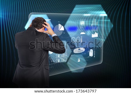 Stressed businessman with hands on head against shiny hexagons on black background