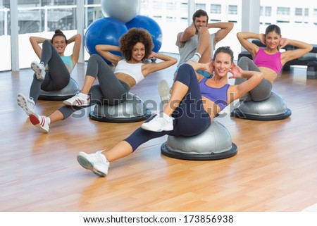 Portrait of cheerful fitness class doing pilates exercise in bright room