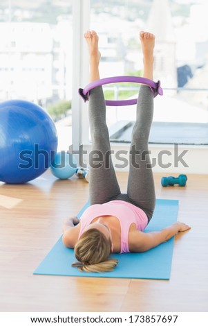 Full length of a sporty young woman exercising in fitness studio