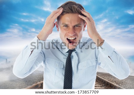 Stressed businessman shouting against train tracks leading to city on the horizon