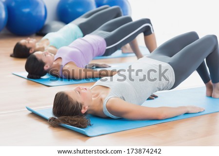 Side view of fit class exercising in row at fitness studio