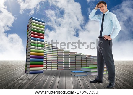 Thoughtful businessman with hand on head against steps made of books against sky