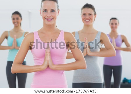 Beautiful young sporty women with joined hands in fitness studio