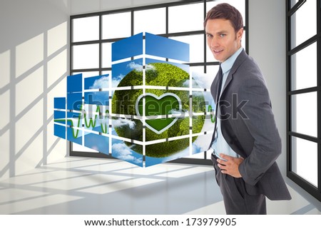 Cheerful businessman standing with hands on hips against room with a lot of windows