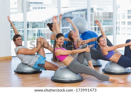 side view of sporty people stretching hands at yoga class in fitness studio