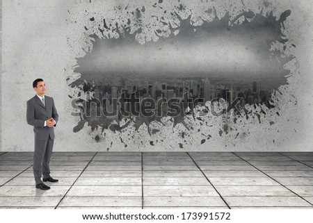 Businessman with hands folded against splash showing cityscape