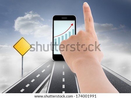 Female hand pointing against road over clouds with road signs on it